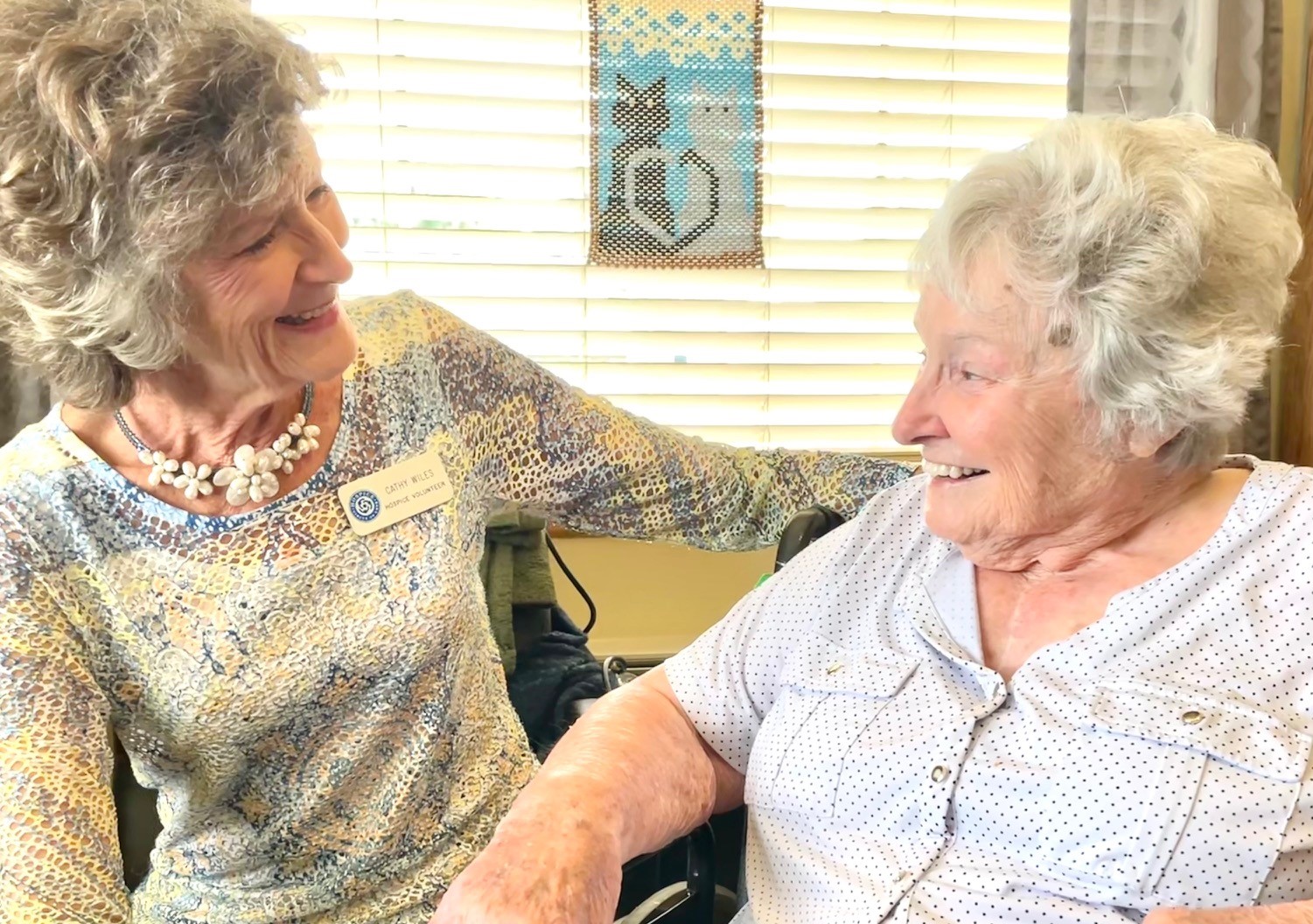 Two women are smiling and talking together.