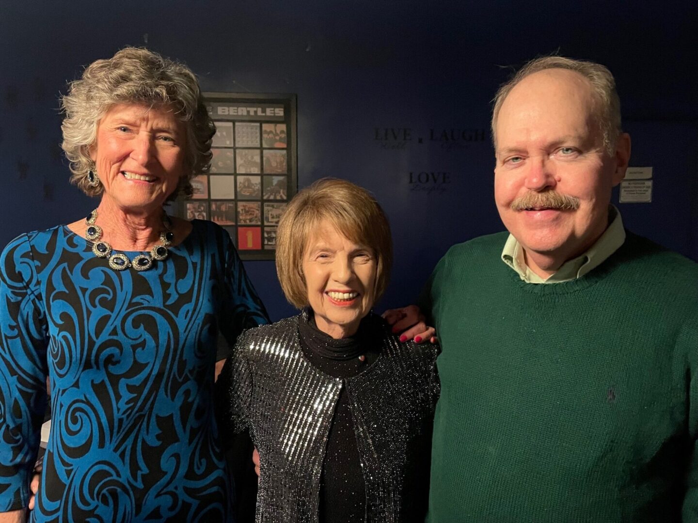 A family posing for a picture in front of a wall.